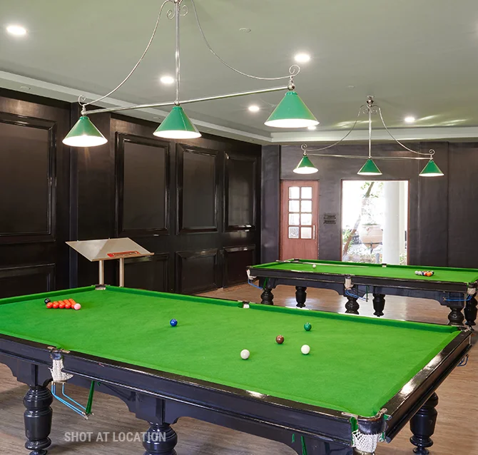 A billiard table located in a room, highlighting a pool table amidst a warm and welcoming environment.