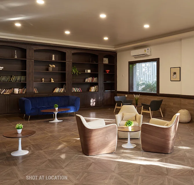 An elegant library room with a prominent bookcase and stylish chairs, perfect for reading and leisure activities.