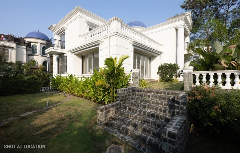 A white house featuring a prominent blue dome atop its roof, set against a clear sky.
