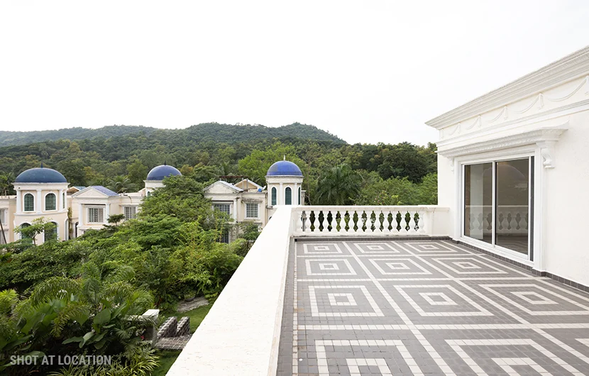 A balcony with a tiled surface, showcasing a breathtaking view of the surrounding mountains.