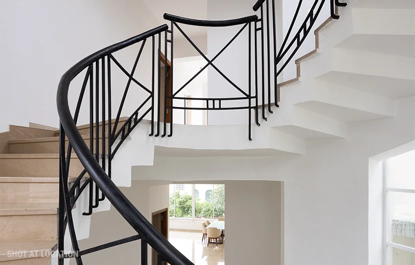 A white staircase featuring elegant black railings and polished white marble steps, showcasing a modern design aesthetic.