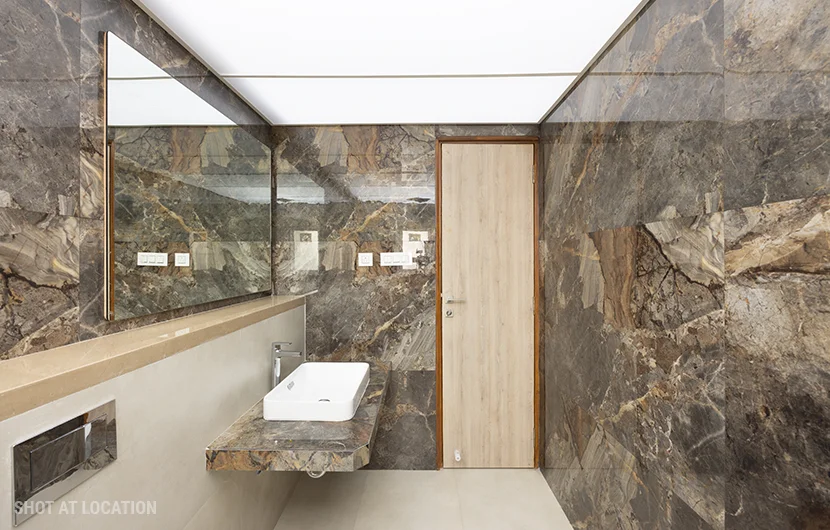 A luxurious bathroom featuring elegant marble walls and a stylish sink, showcasing a sophisticated design aesthetic.